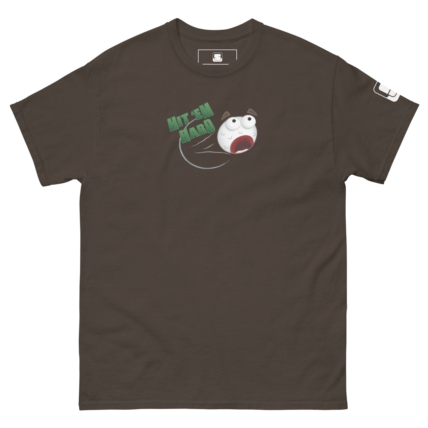 A chocolate brown t-shirt is laid flat, featuring a colorful graphic in the center. The graphic depicts a distressed cartoon golf ball with wide eyes and an open mouth, flying through the air. Above the golf ball, the phrase "HIT 'EM HARD" is printed in bold, green letters. The golf ball leaves a streak behind it, emphasizing its high speed. The right sleeve has a small white logo patch. The bold graphic stands out against the black background, creating a fun and energetic design.