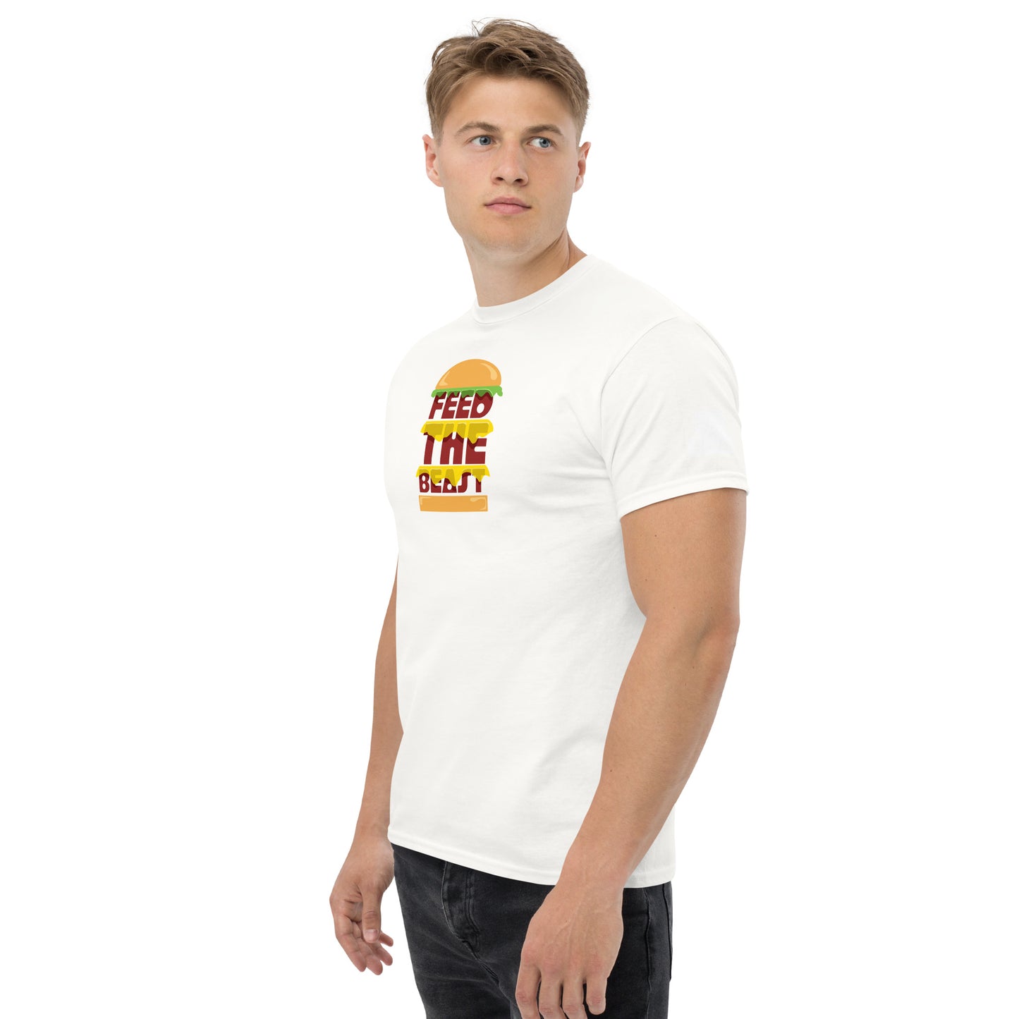 Man with a focused look wearing a white t-shirt featuring the text 'FEED THE BEAST' with a burger graphic in yellow and red tones, standing with a confident posture against a white background