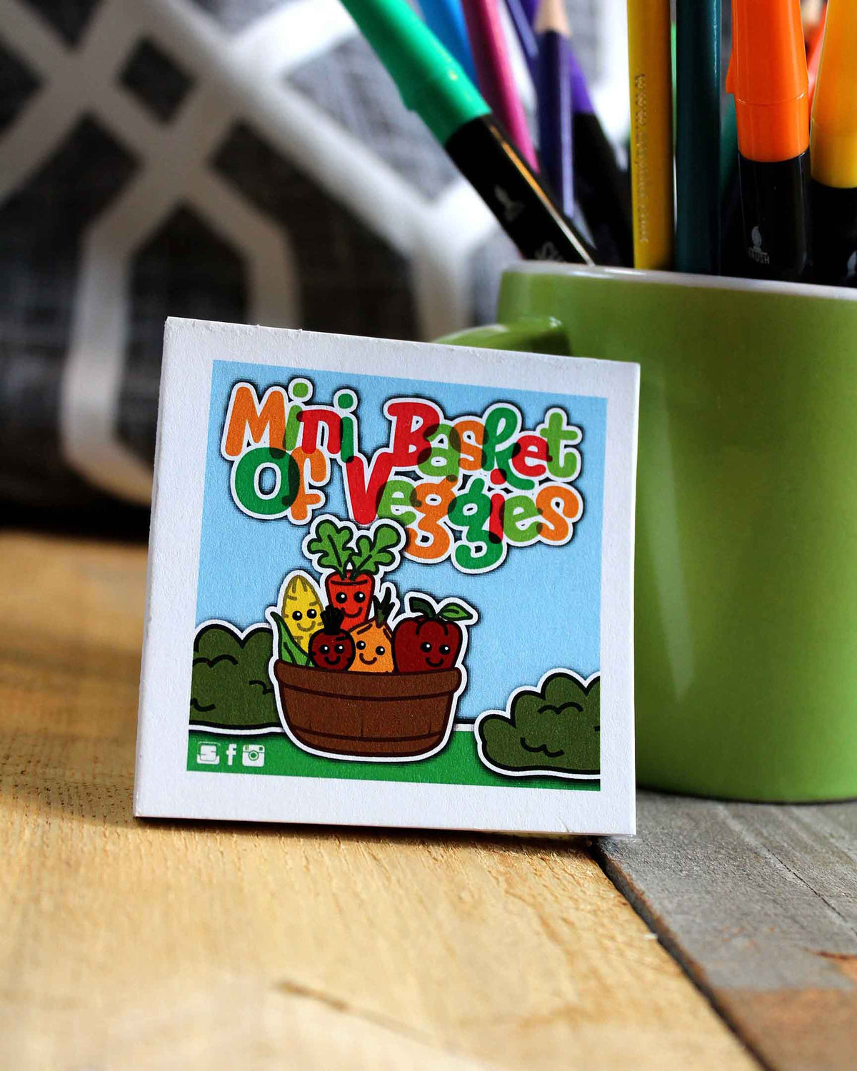 Mini Baskets of Vegetables packaging with colorful text and illustrations on a wooden surface.
