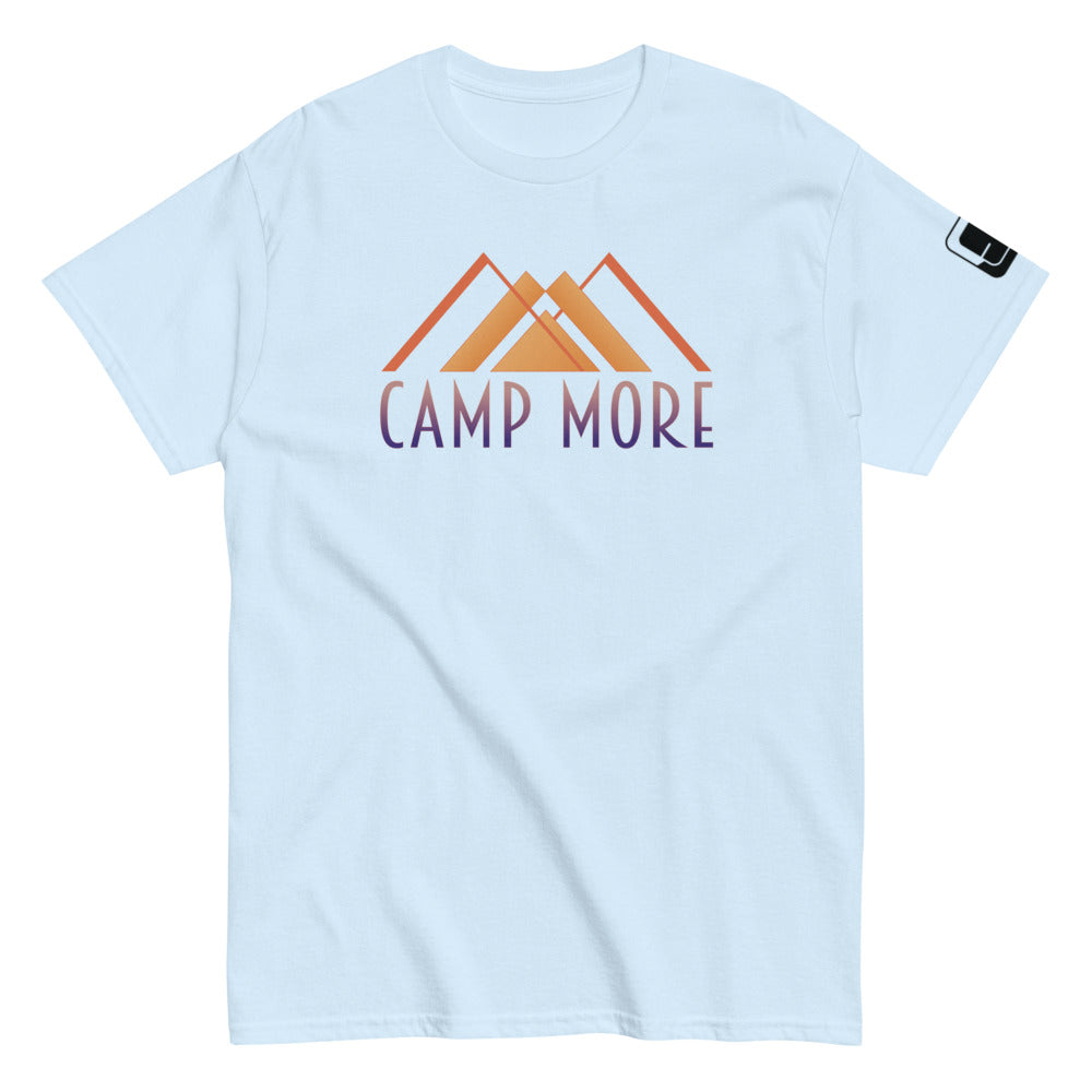 Light Blue t-shirt laid flat showcasing the 'CAMP MORE' slogan in purple with an orange mountain range illustration, complete with a black logo patch on the sleeve, isolated on a white background.