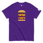 Purple t-shirt with 'FEED THE BEAST' in bold, stacked yellow and red lettering embedded in a detailed burger graphic, featuring a small logo patch on the sleeve, presented on a plain white background.