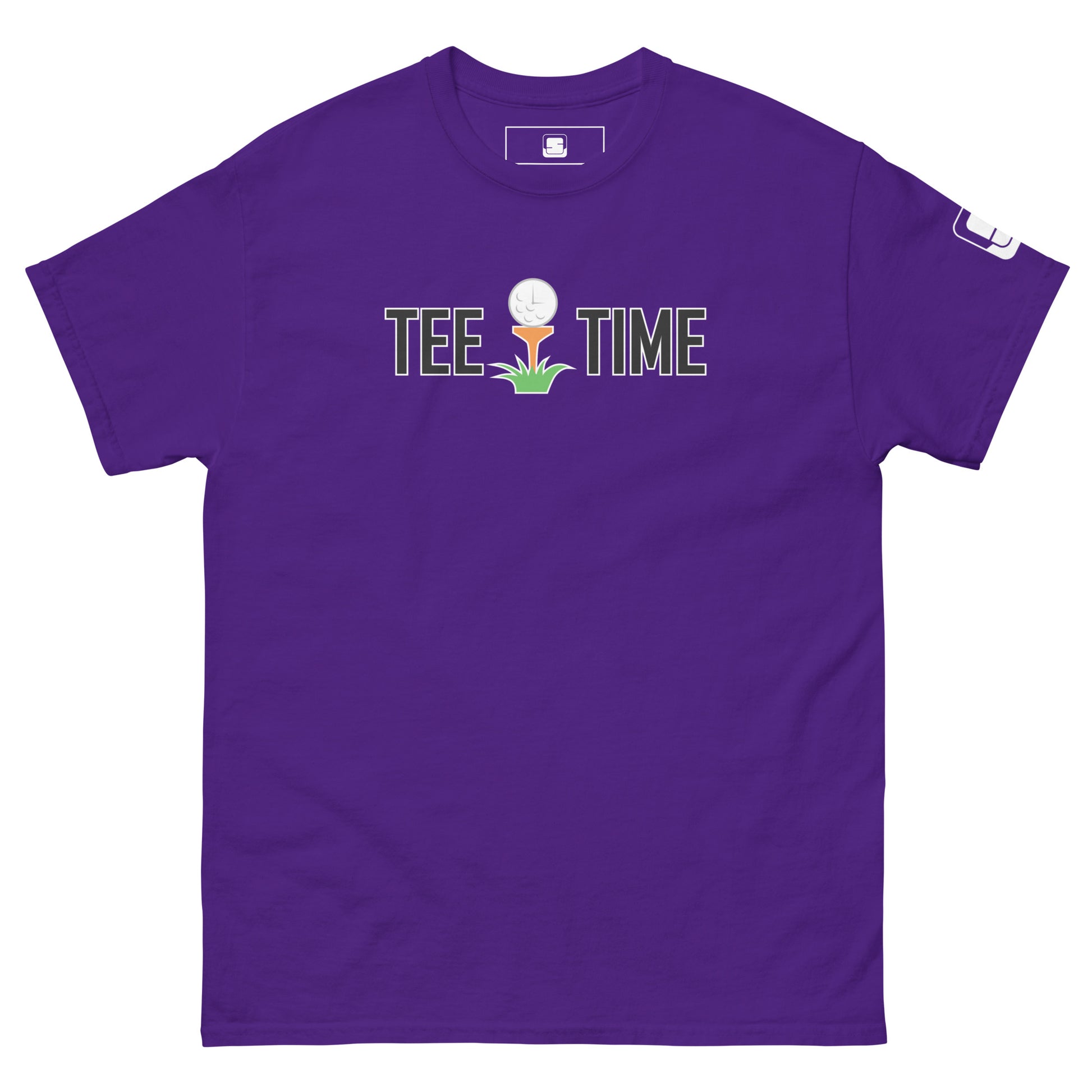 The image presents a bold purple t-shirt with the text "TEE TIME" and an image of a golf ball on a tee with a small green sprout at the base. The graphic is centered on the chest area. A small white logo appears on the right sleeve. The t-shirt is spread out flat to display its design clearly against a plain background, highlighting the vibrant color and the playful, golf-inspired motif