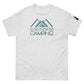 A heather gray t-shirt featuring a light teal graphic of two overlapping mountains with the phrase "I'D RATHER BE CAMPING" in black, stylish font centered below the mountains. The design is placed on the upper chest of the shirt, and there is a small logo patch on the right sleeve, enhancing the shirt's outdoorsy theme.