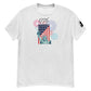 A heather gray t-shirt showcasing a vibrant Fourth of July-themed design. The graphic displays the Statue of Liberty alongside an American flag, with colorful fireworks in red, blue, and purple bursting around it. Above the imagery, the year '1776' is prominently featured in bold numerals, evoking the spirit of American independence.