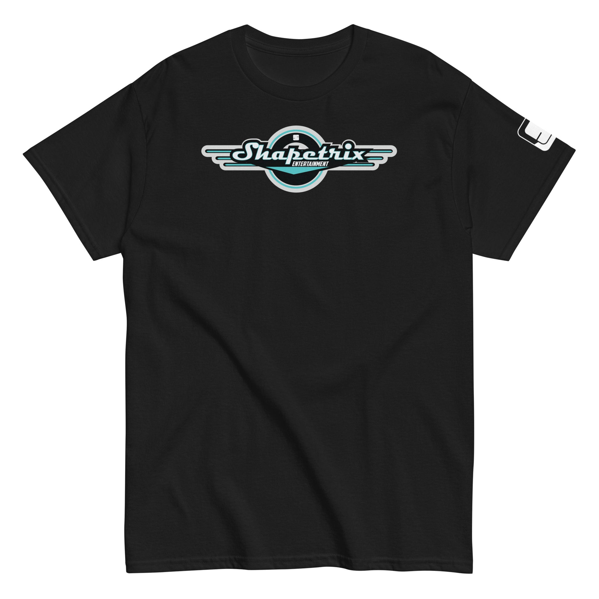A flat-laid black t-shirt featuring the Shapetrix Entertainment logo prominently on the chest. The logo, designed with stylized white and teal lettering, is framed by a black circular backdrop with wing-like extensions on either side, creating a dynamic, retro-modern look. The left sleeve of the shirt displays a small, rectangular tag with the Shapetrix Entertainment logo, adding an additional branding detail to the garment's sleek and casual design.
