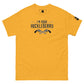 The image shows a golden yellow t-shirt with a black graphic print. The text "I'm Your Huckleberry" is displayed in a stylish, Western-inspired font, underscored by an illustration of two crossed revolvers. The design conveys a bold, adventurous theme reminiscent of classic Western films. A small logo patch is present on the sleeve, adding a modern touch to the shirt's otherwise nostalgic feel.