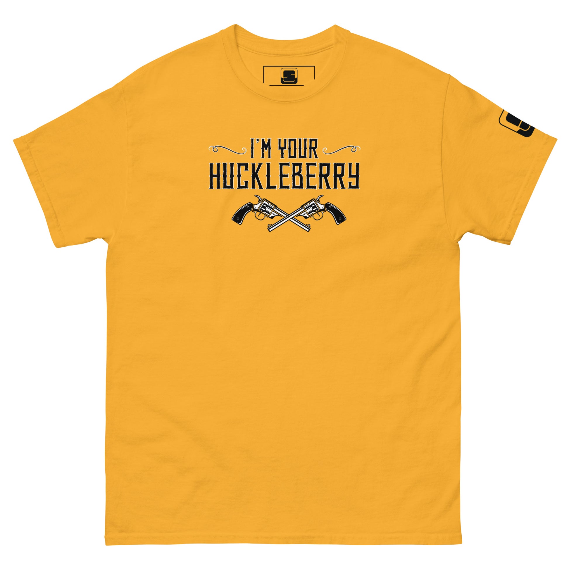 The image shows a golden yellow t-shirt with a black graphic print. The text "I'm Your Huckleberry" is displayed in a stylish, Western-inspired font, underscored by an illustration of two crossed revolvers. The design conveys a bold, adventurous theme reminiscent of classic Western films. A small logo patch is present on the sleeve, adding a modern touch to the shirt's otherwise nostalgic feel.