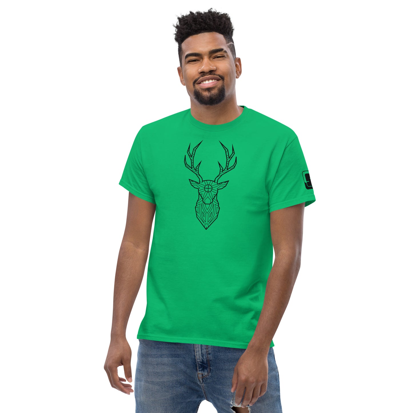 A cheerful African American man with a stylish beard models a bright green T-shirt adorned with a black geometric deer head design. He stands confidently, hands in jeans pockets, against a plain white background, smiling warmly at the viewer.
