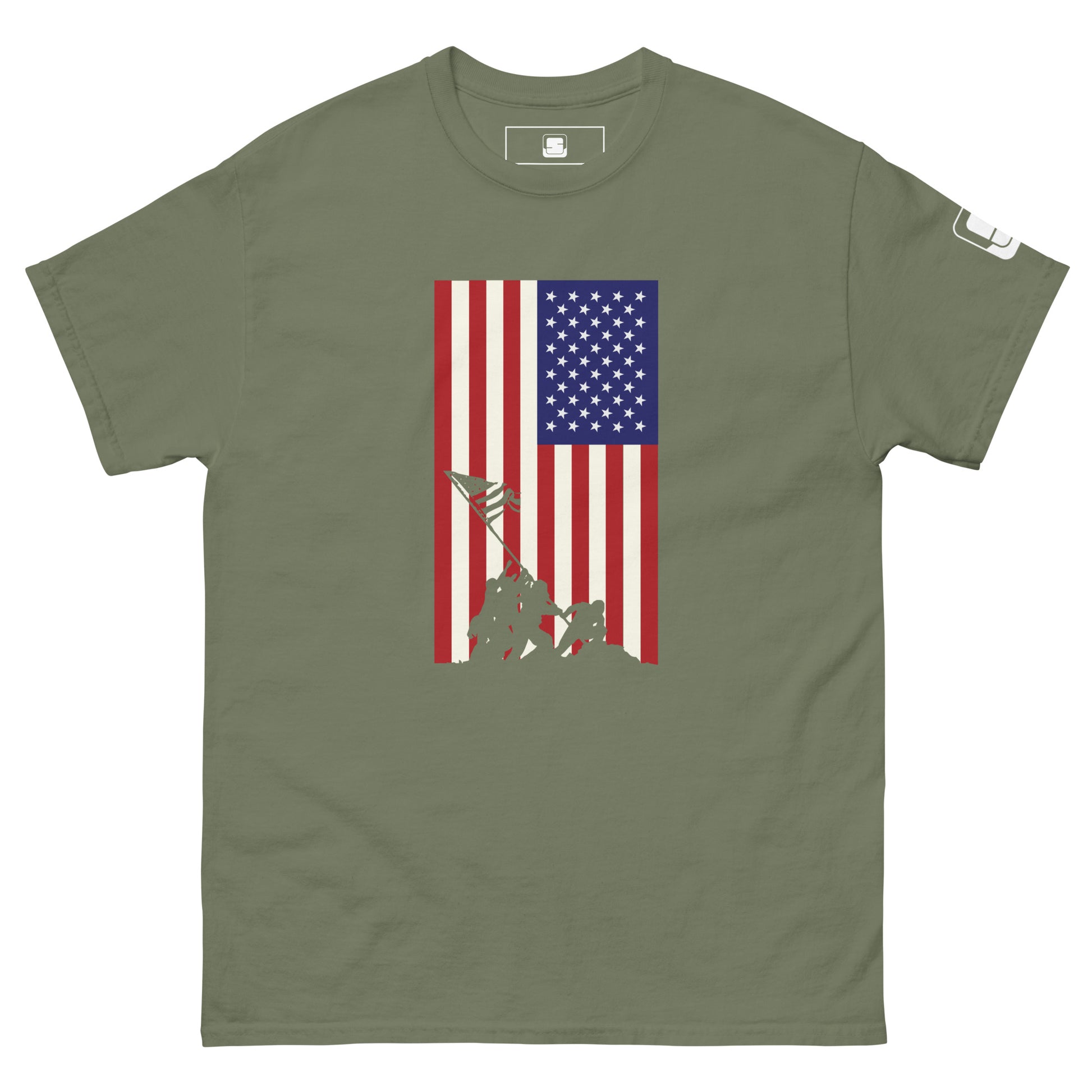 A military green T-shirt displays a vertically aligned American flag, with a blue square full of stars in the upper left and stripes of red and white extending downwards. At the base of the flag, there's a silhouette of the iconic Iwo Jima flag-raising scene, depicting soldiers working together to hoist the flag. This graphic blends historical reverence with a modern style on the T-shirt.