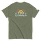 An military green t-shirt showcasing a vibrant mountain motif with three overlaid peaks in yellow and orange. Below the mountain graphic, the phrase "HAPPY CAMPER" is presented in a soft blue, bold sans-serif font. This comfortable, crew-neck shirt is styled for a relaxed fit, ideal for outdoor adventures or casual wear.