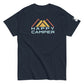 A navy blue t-shirt featuring the "Happy Camper" design. This casual crew-neck shirt displays a colorful mountain motif with three overlaid peaks in shades of yellow and orange, beneath which the phrase "HAPPY CAMPER" is printed in bold, pale blue sans-serif font. The t-shirt is shown on a plain white background to highlight the vivid design.