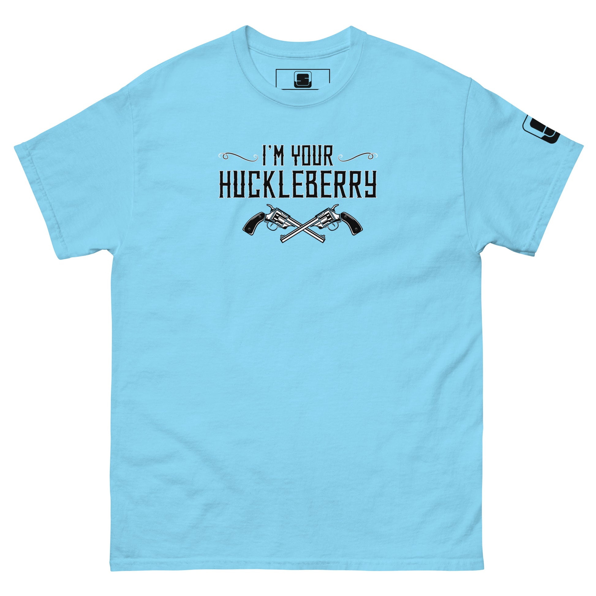 The image features a light blue t-shirt with the phrase "I'm Your Huckleberry" printed in black in a Western-style font, accompanied by an illustration of two crossed revolvers beneath the text. The design evokes a classic Western motif, suggesting themes of old-school bravery or confrontation. A small logo patch is visible on the sleeve, adding a contemporary detail to the otherwise vintage-inspired shirt.
