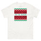 A white t-shirt with a festive, holiday-themed graphic resembling a traditional Christmas sweater design printed in the center. The graphic features multiple rows of red and black patterns, including stars and geometric shapes on a green background. Across the middle, in a contrasting white font, reads the phrase 'TIS THE SEASON', encapsulating the holiday spirit.