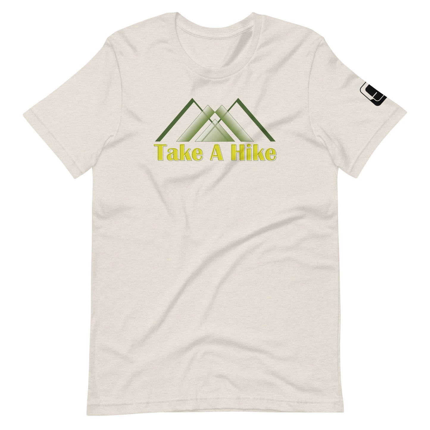 A light cream-colored t-shirt features a central graphic of three overlapping stylized mountain peaks in shades of green, underlined by the phrase "Take A Hike" in bold yellow letters. The shirt has a relaxed fit with a round neckline and short sleeves, sporting a small black logo patch on the right sleeve. The design is placed prominently across the chest, presenting a clear and appealing call to outdoor enthusiasts.