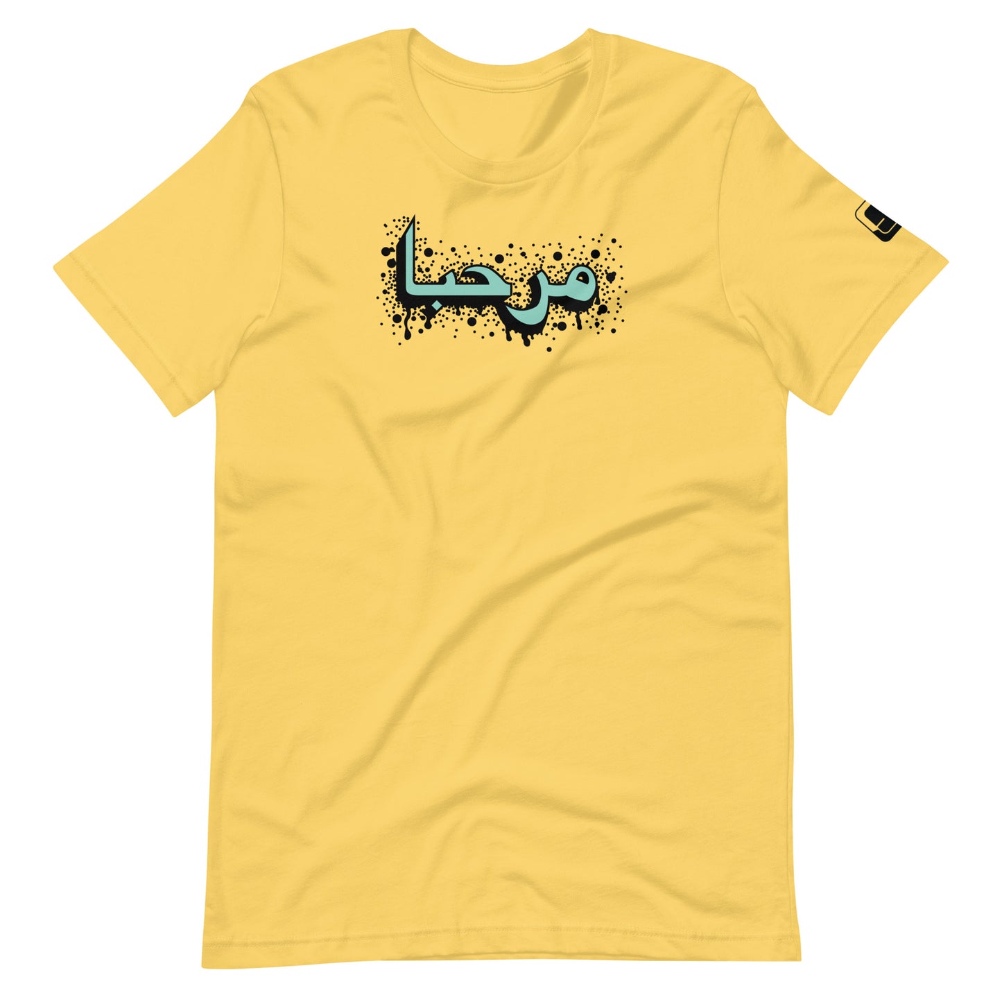 Lemon yellow t-shirt featuring central turquoise Arabic calligraphy with black shadow and scattered ink dots, accompanied by a small black logo patch on the sleeve, displayed against a white background.