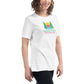 A joyful woman models a white t-shirt featuring the "Shady Pines Escape Club" logo. The logo depicts two green pine trees on either side of a stylized sunset with horizontal stripes in yellow, pink, purple, and blue. Below the sunset, "SHADY PINES" is written in bold, green text, while "ESCAPE CLUB" is detailed below in smaller pink letters. The simple yet colorful design of the t-shirt is both eye-catching and playful, perfect for casual wear.